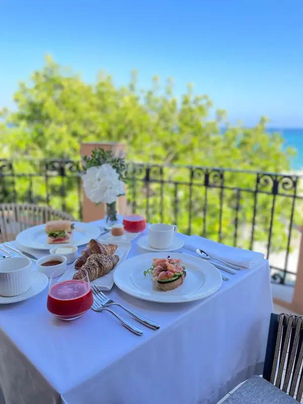 Une table est dressée avec un petit-déjeuner face à la mer.