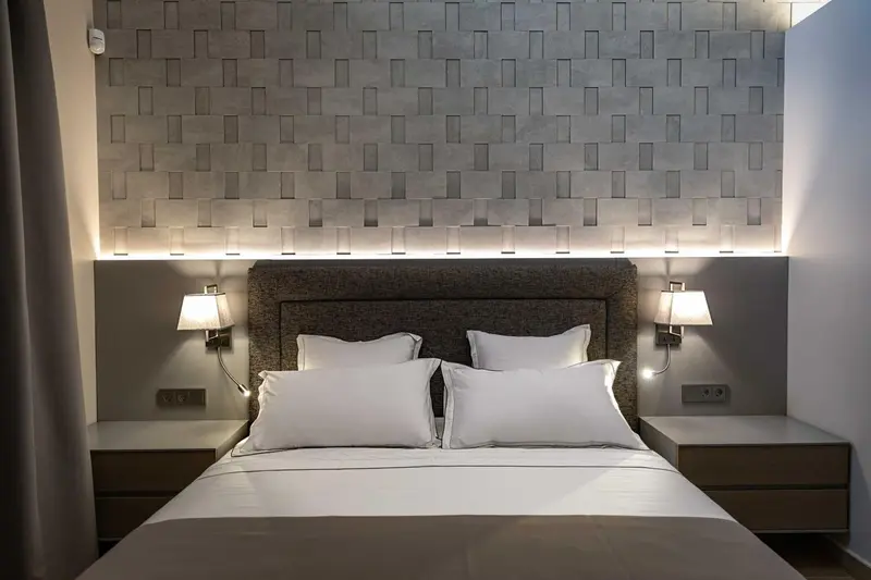 Un lit double avec des oreillers blancs dans une chambre moderne.