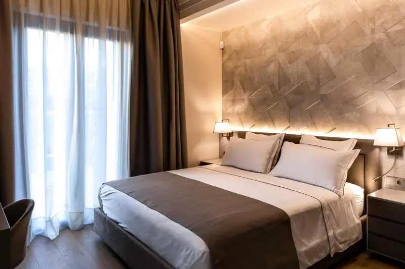 Une chambre lumineuse avec un grand lit et des rideaux.