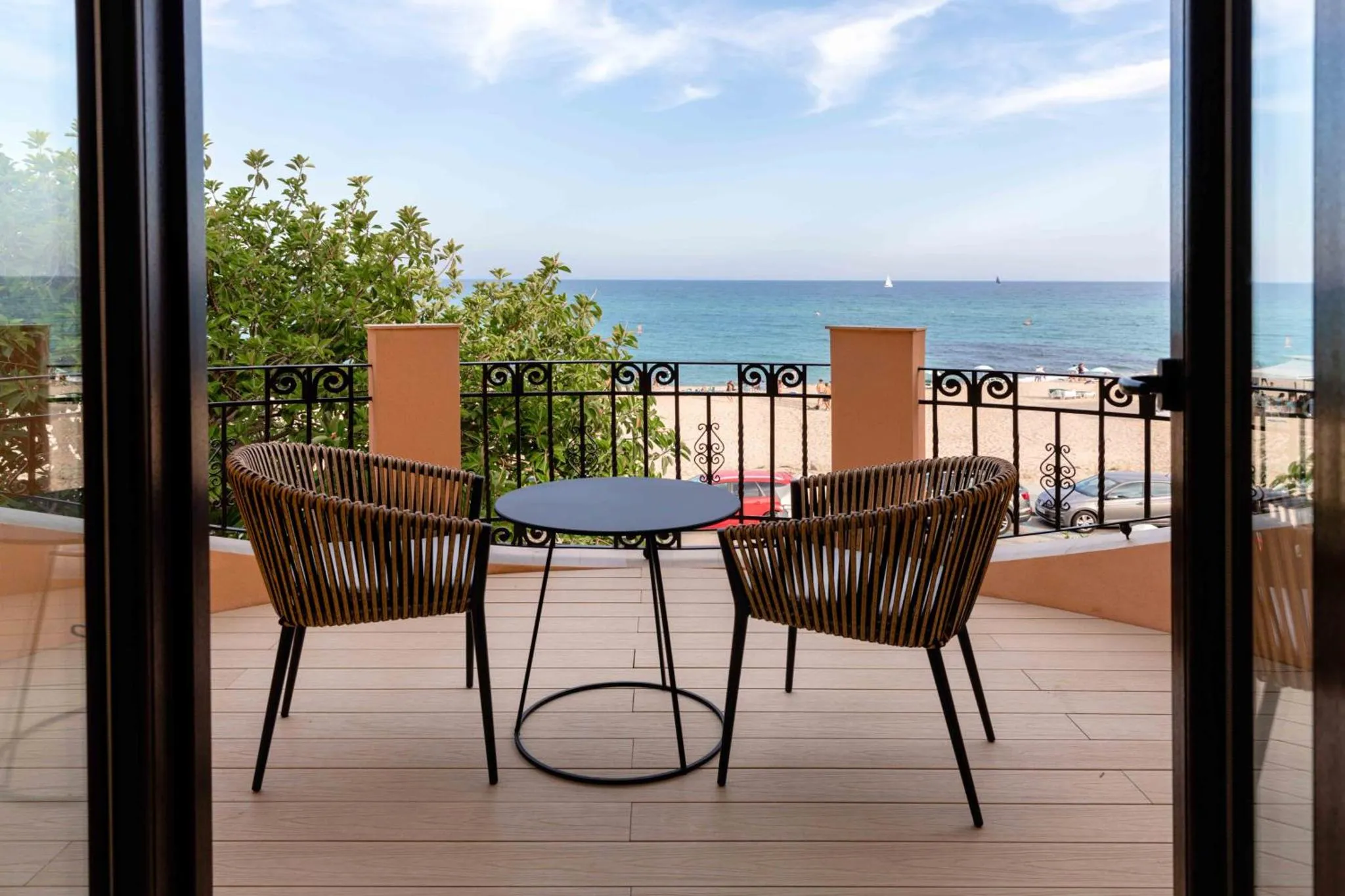 Terrasse avec mobilier en osier donnant sur la mer.