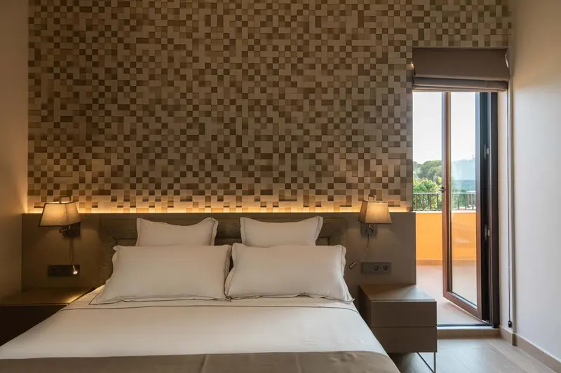 Une chambre avec un grand lit et un accès à une terrasse.
