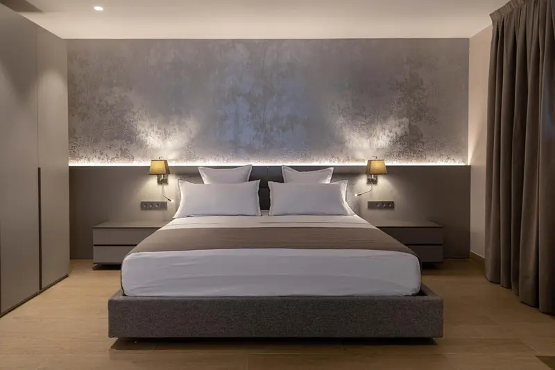Une chambre moderne avec un grand lit et un éclairage subtil.