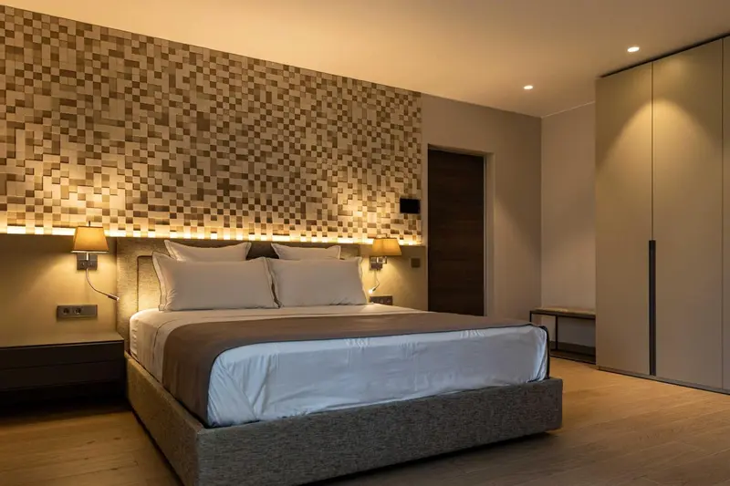 Une chambre moderne avec un grand lit et un mur texturé.