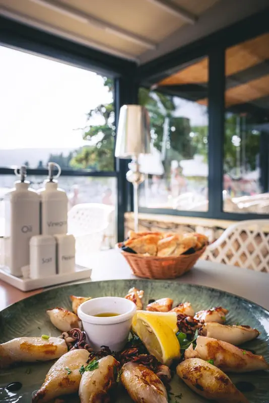 Une table est dressée avec des plats de fruits de mer et des condiments.