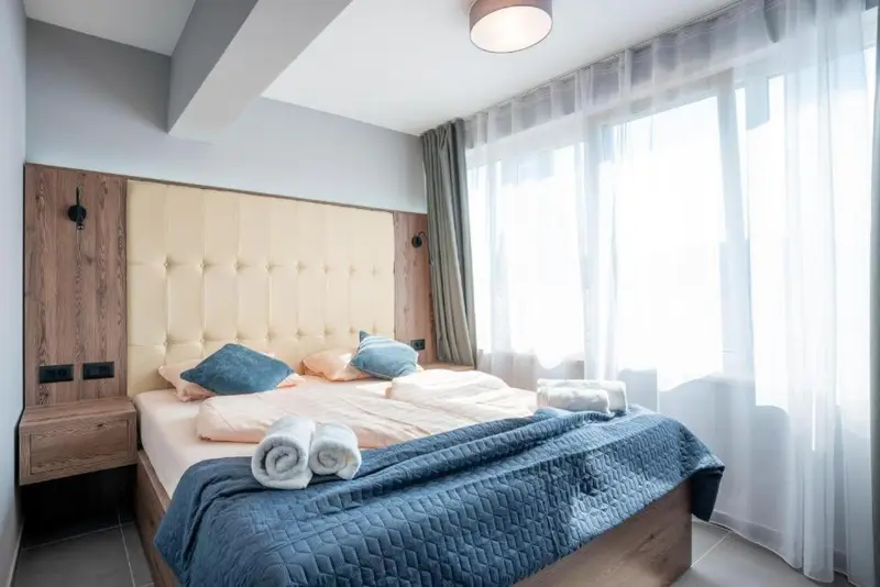 Une chambre lumineuse avec un grand lit et des oreillers décoratifs.