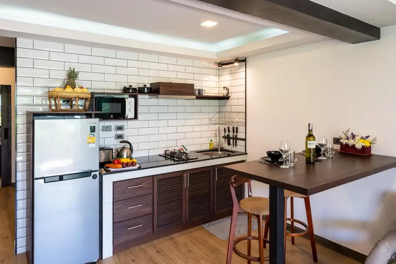 Une kitchenette moderne avec un plan de travail et des tabourets de bar.