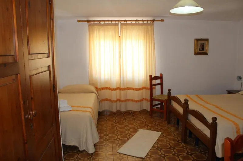 Une chambre simple avec deux lits et une fenêtre.