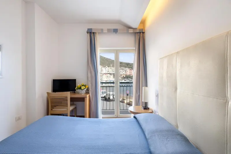 Une chambre lumineuse avec un lit et une vue sur la mer.