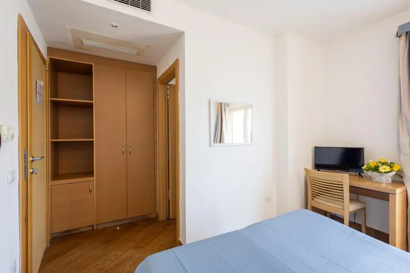 Une chambre lumineuse avec un bureau et un placard intégré.