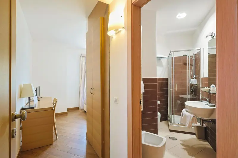 Une chambre lumineuse s'ouvre sur une salle de bain avec douche à l'italienne.