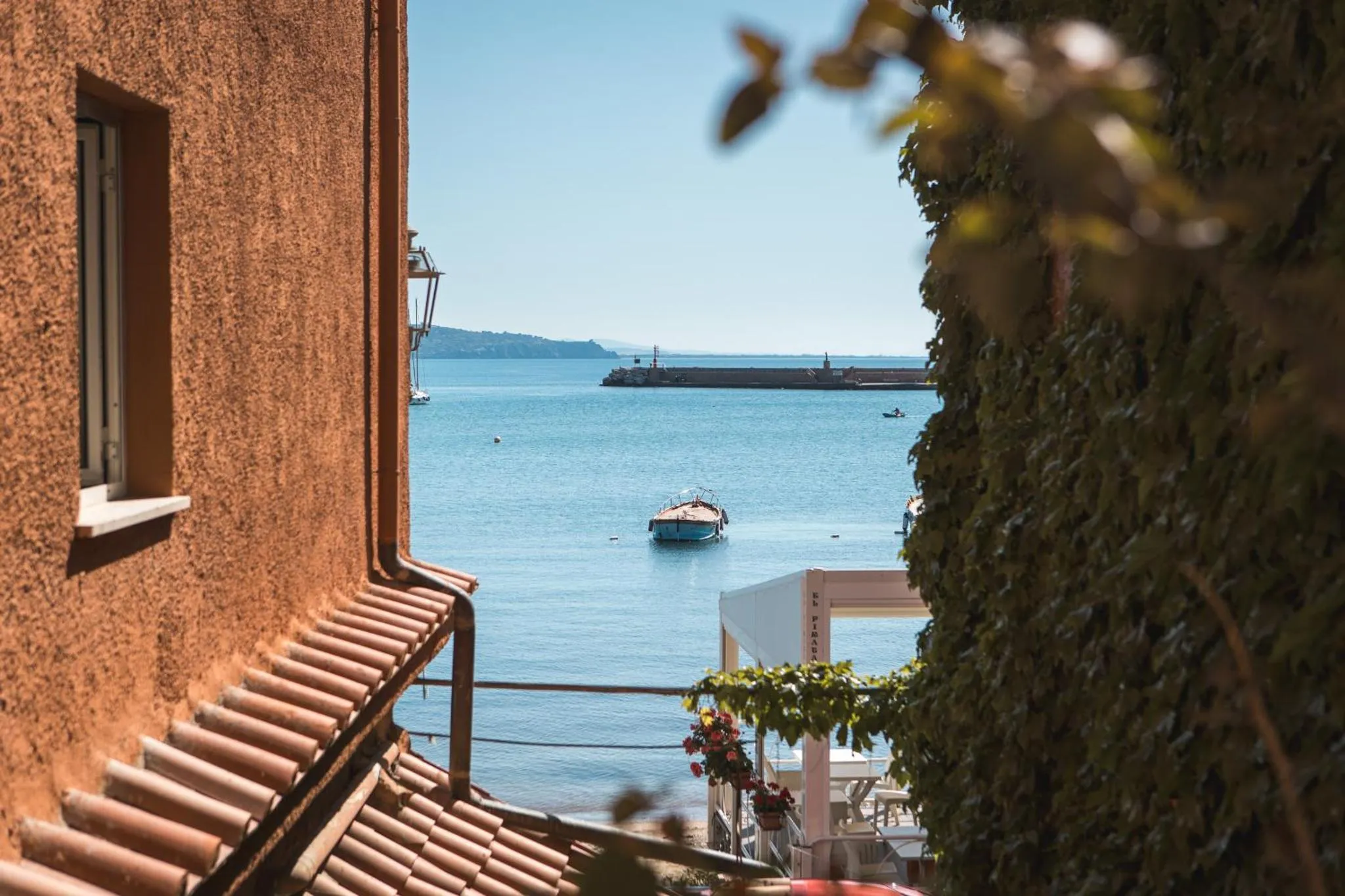 Vue sur la mer depuis un balcon fleuri.
