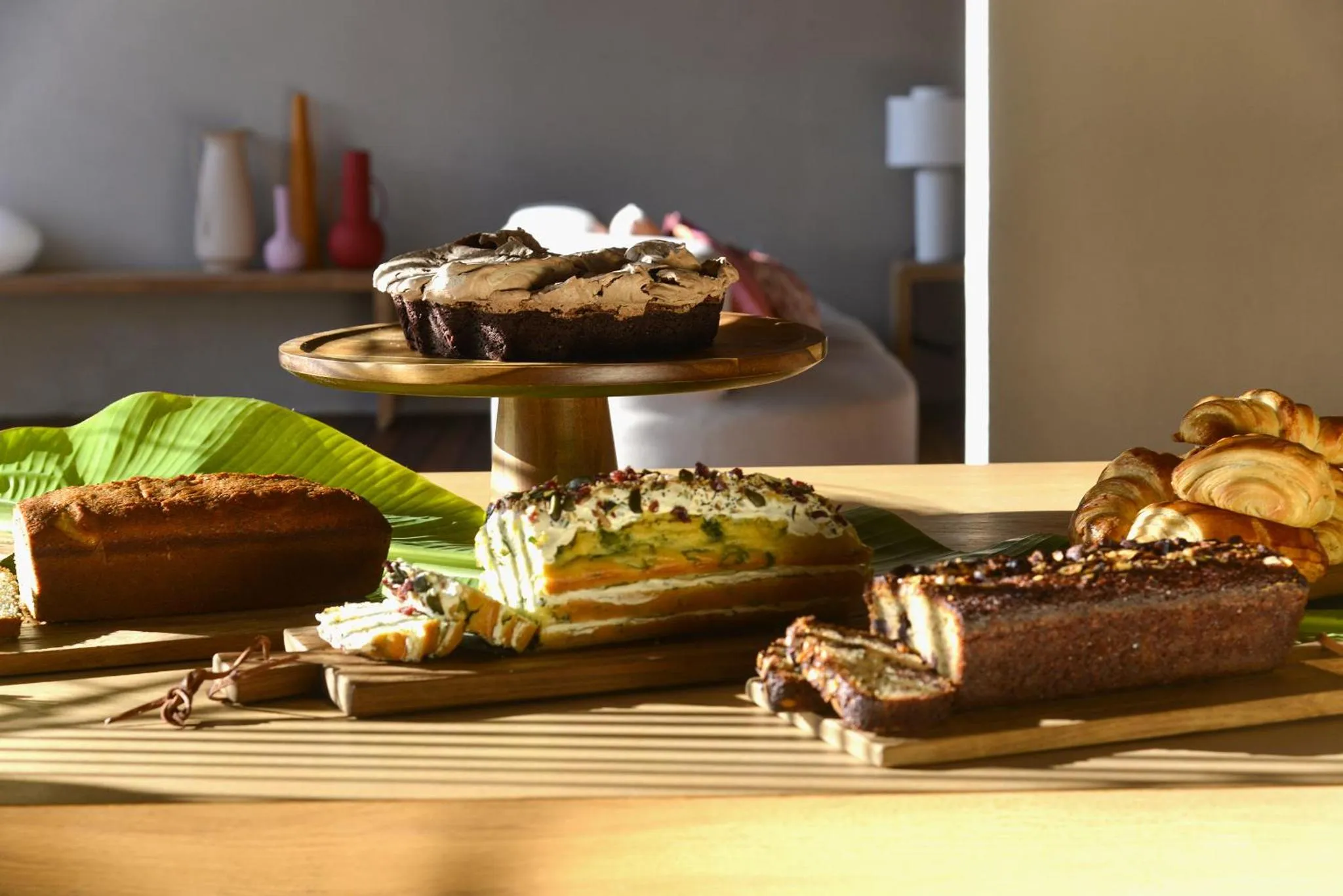 Assortiment de pâtisseries et viennoiseries présentées sur une table en bois.