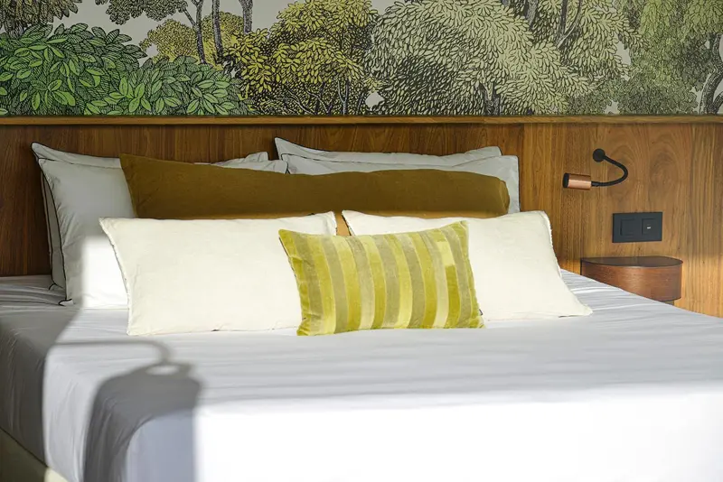Un lit confortable avec des oreillers et des coussins dans une chambre décorée.