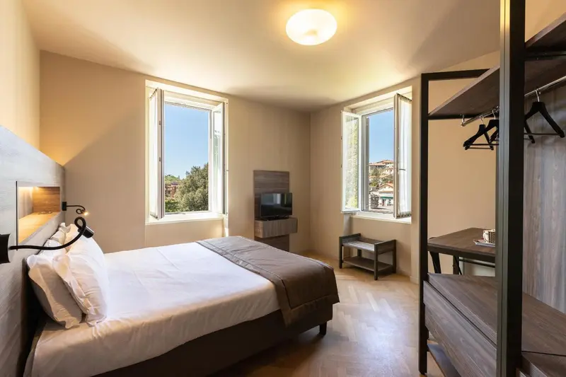 Une chambre lumineuse avec un lit double et un bureau.