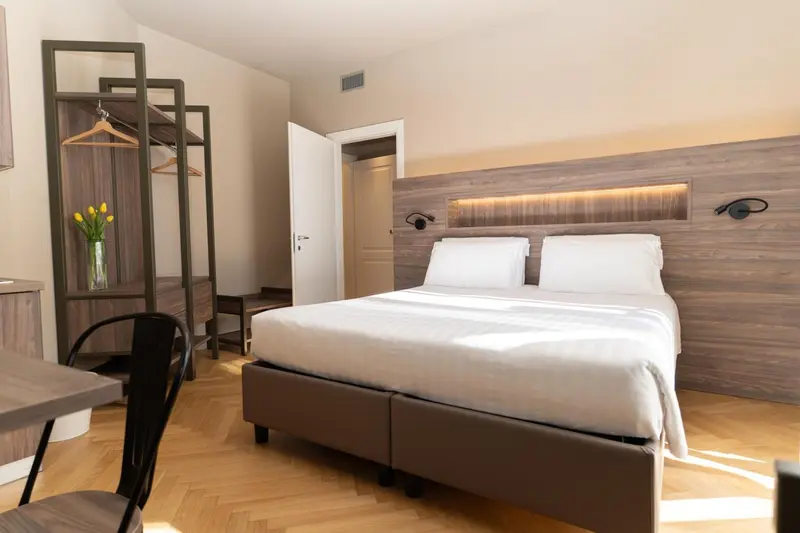 Une chambre lumineuse avec un grand lit et un espace rangement.