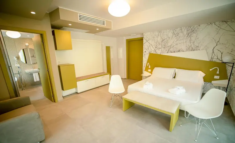 Une chambre lumineuse avec un lit double et un espace détente.