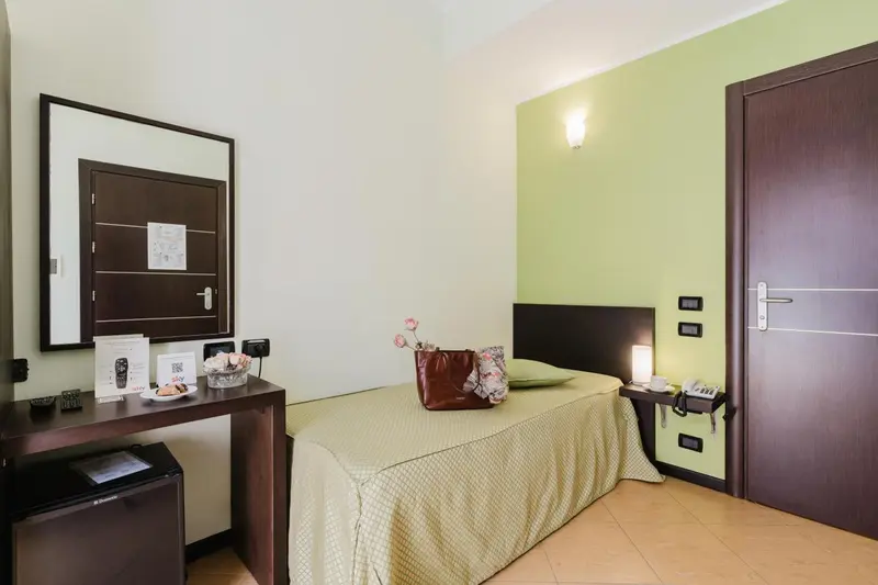 Une chambre lumineuse avec un lit simple et un bureau.