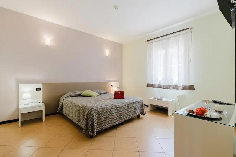 Une chambre lumineuse avec un lit et une table de chevet.