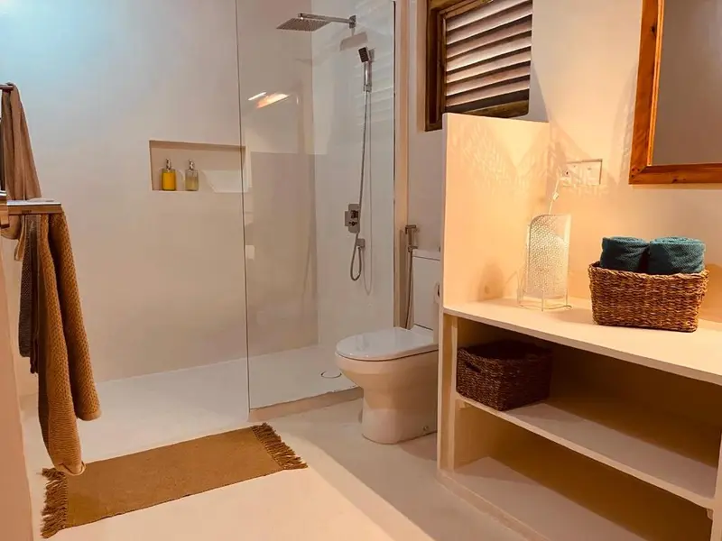 Une douche à l'italienne moderne avec des serviettes et des accessoires décoratifs.