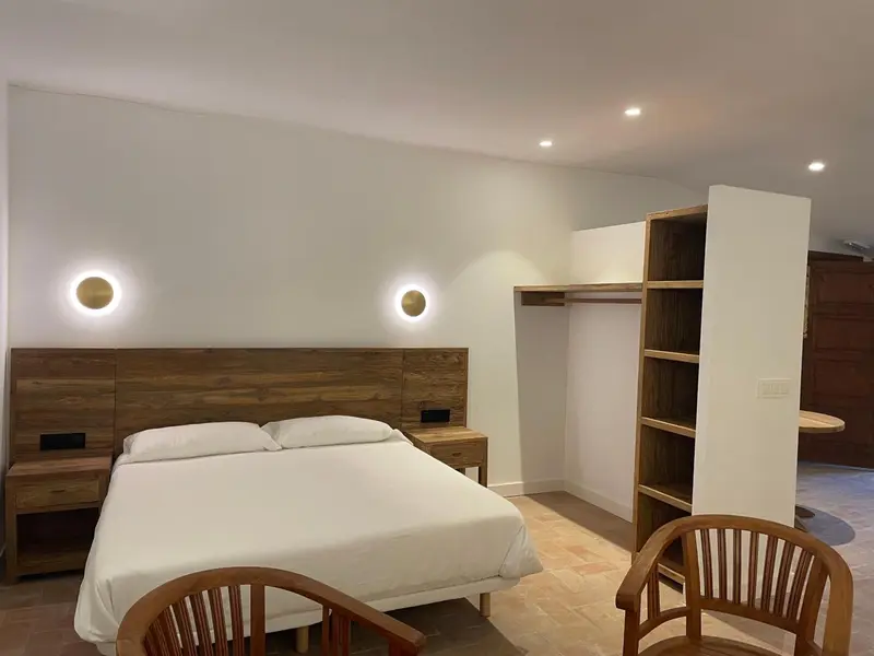 Une chambre lumineuse avec un grand lit et une décoration en bois.