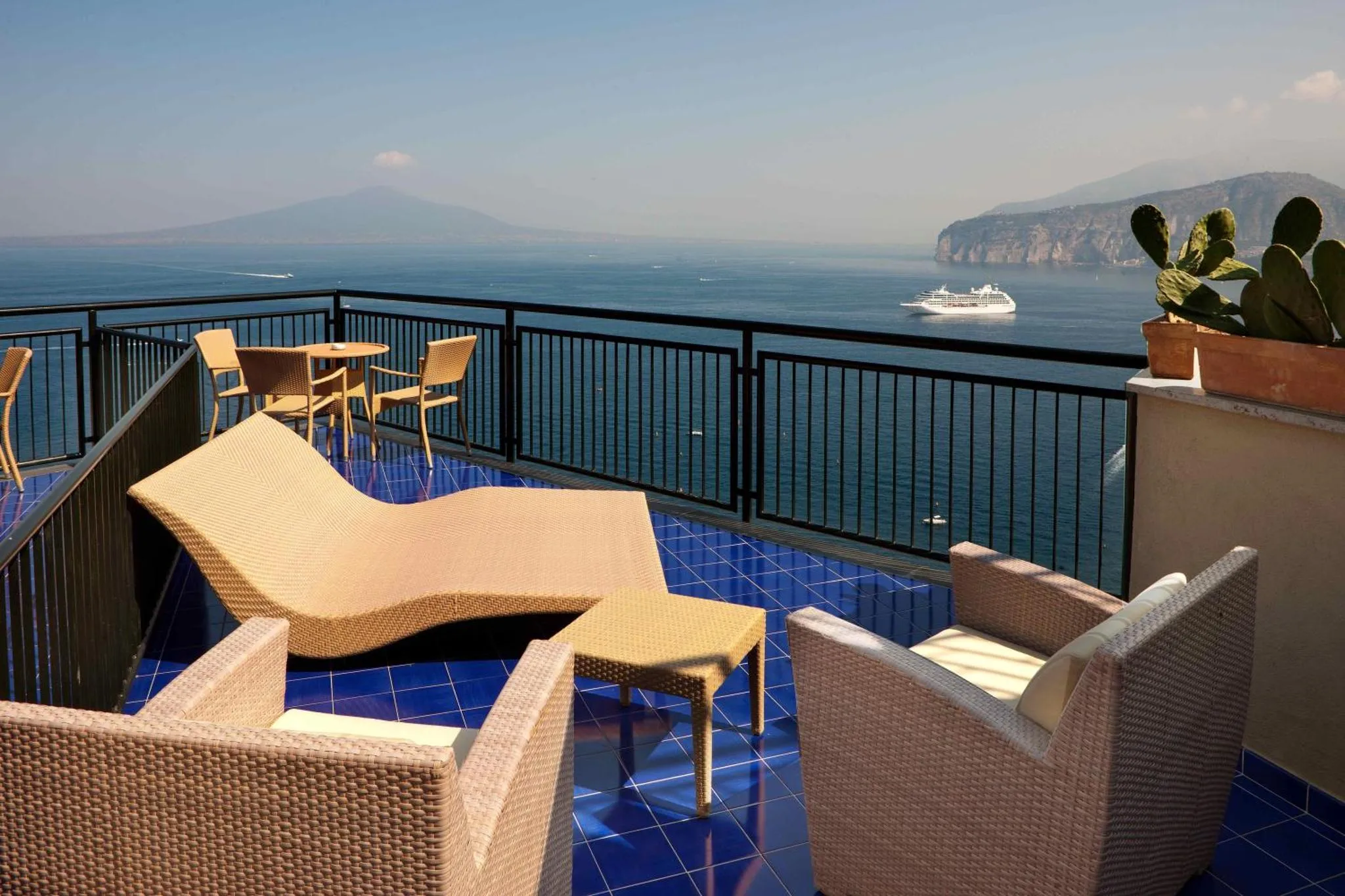 Terrasse avec mobilier d'extérieur et vue sur la mer.