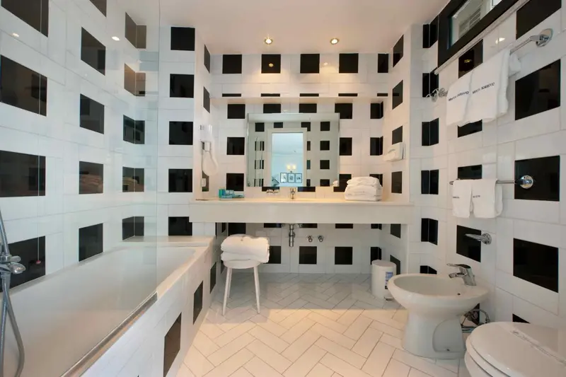 Une salle de bain moderne avec des carreaux noirs et blancs et une baignoire.
