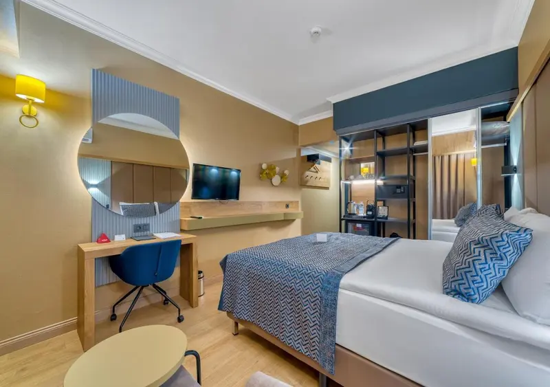 Une chambre d'hôtel lumineuse avec un lit et un bureau.