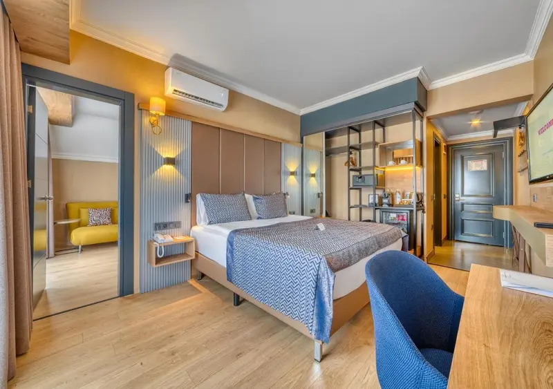 Chambre lumineuse avec un grand lit et un coin salon.