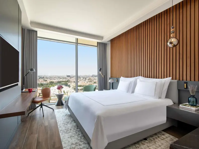 Chambre moderne avec un grand lit et une vue sur la ville.