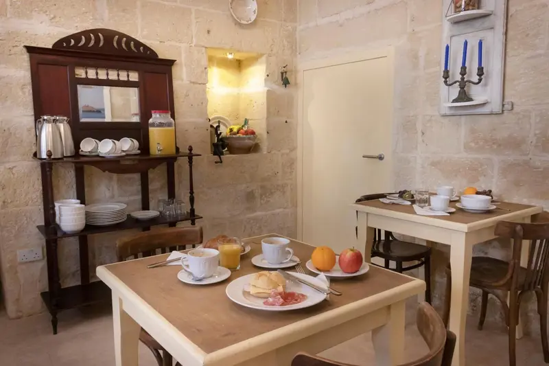 Une table est dressée pour le petit-déjeuner dans une pièce lumineuse.
