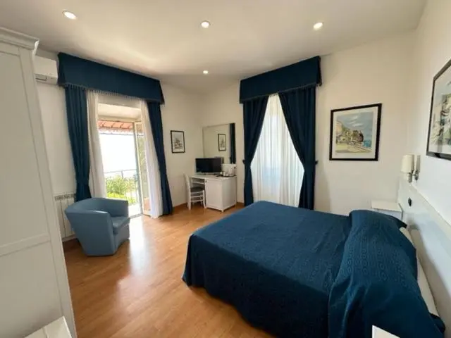 Chambre lumineuse avec un lit recouvert d'une couverture bleue et un fauteuil.