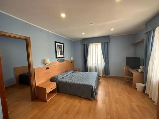 Une chambre lumineuse avec un grand lit et un bureau.