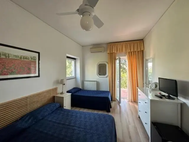 Une chambre lumineuse avec deux lits simples et un accès à une terrasse.