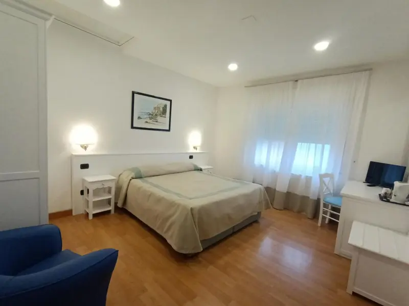 Une chambre lumineuse avec un grand lit et un coin salon.