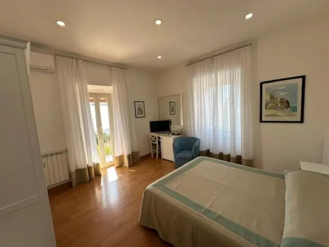 Une chambre lumineuse avec un lit et un bureau près d'une fenêtre.