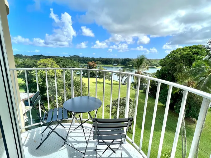 Une terrasse avec une table et des chaises offre une vue sur un paysage verdoyant.