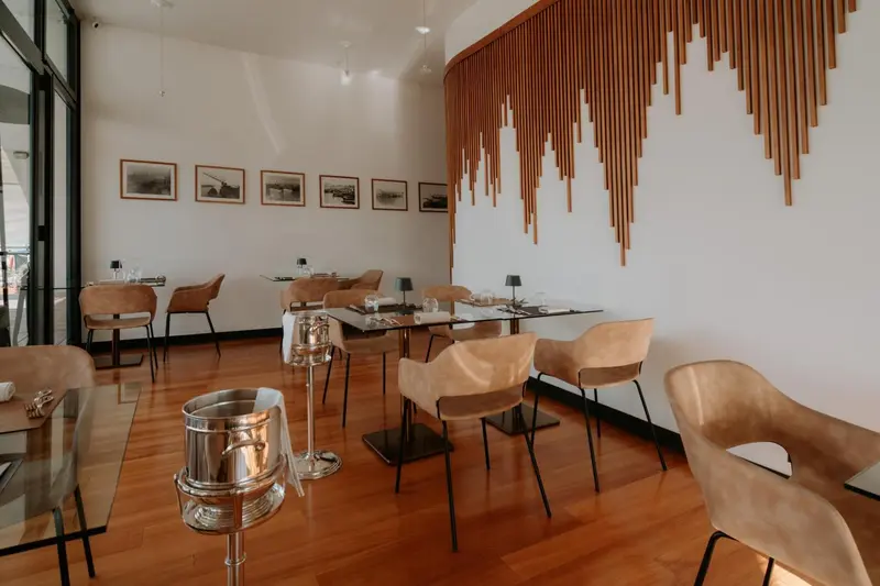 Une salle lumineuse avec des tables dressées pour un repas.