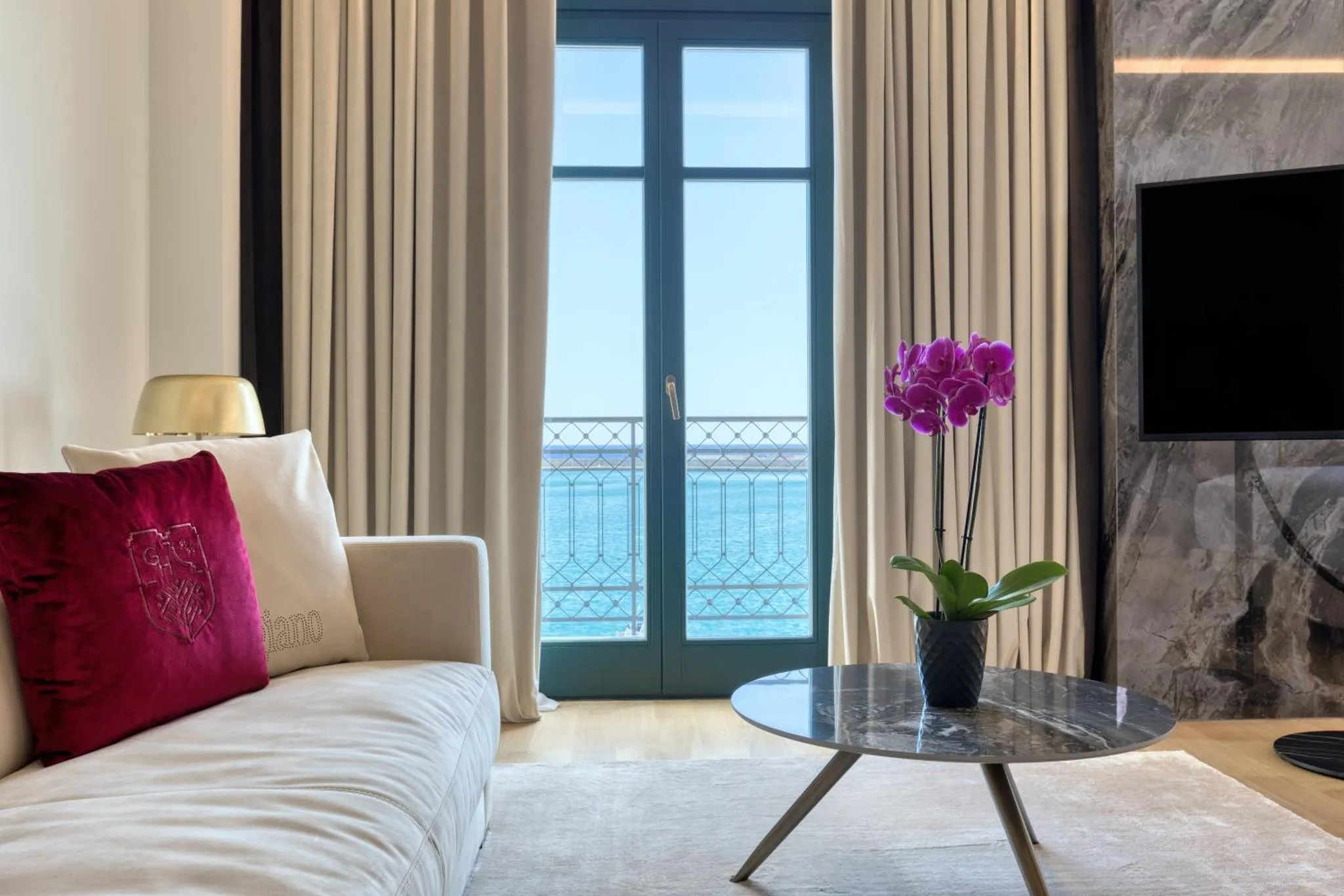 Un salon lumineux s'ouvre sur une vue mer par de grandes baies vitrées.