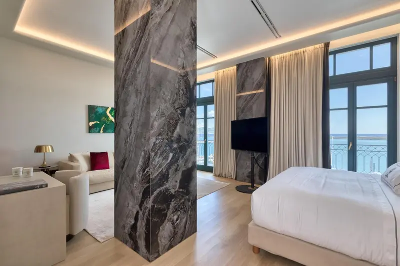 Chambre lumineuse avec un lit confortable et un coin salon.