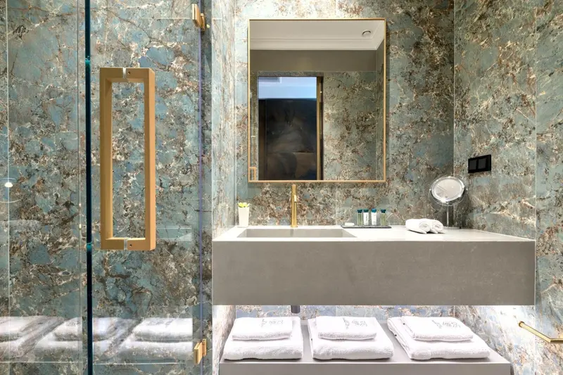 Une salle de bain moderne avec des murs en marbre et une douche à l'italienne.