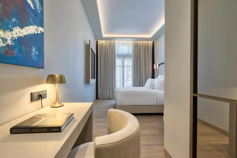 Une chambre lumineuse avec un bureau et un lit confortable.