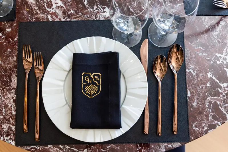 Une table est dressée avec une assiette, des couverts et une serviette.