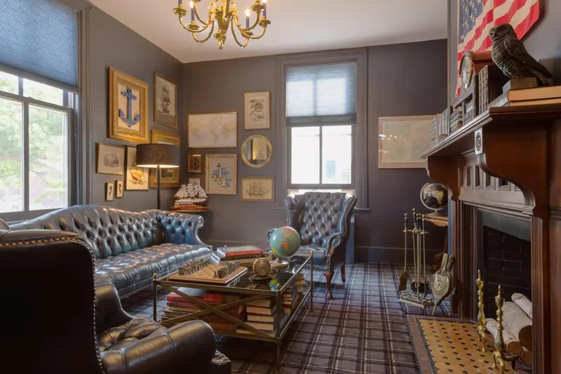 Un salon élégant avec des fauteuils en cuir, un canapé et une cheminée.