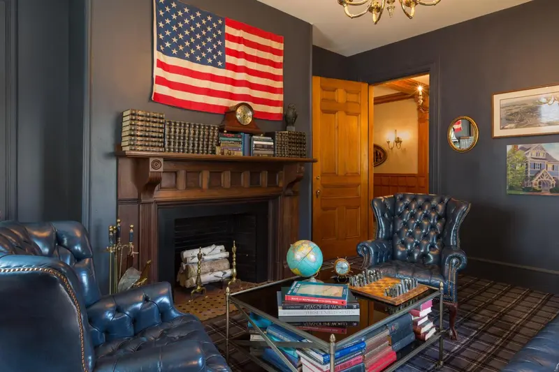 Un salon confortable avec des fauteuils en cuir et une cheminée décorative.