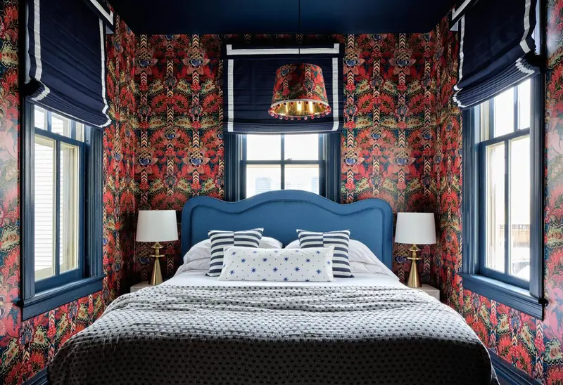 Une chambre à coucher avec un grand lit recouvert d'une courtepointe blanche et de coussins décoratifs.