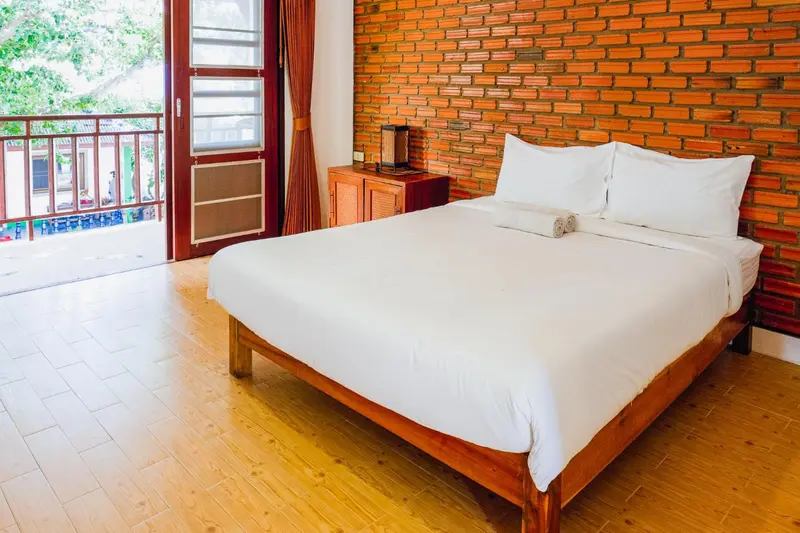 Une chambre lumineuse avec un grand lit recouvert de draps blancs.