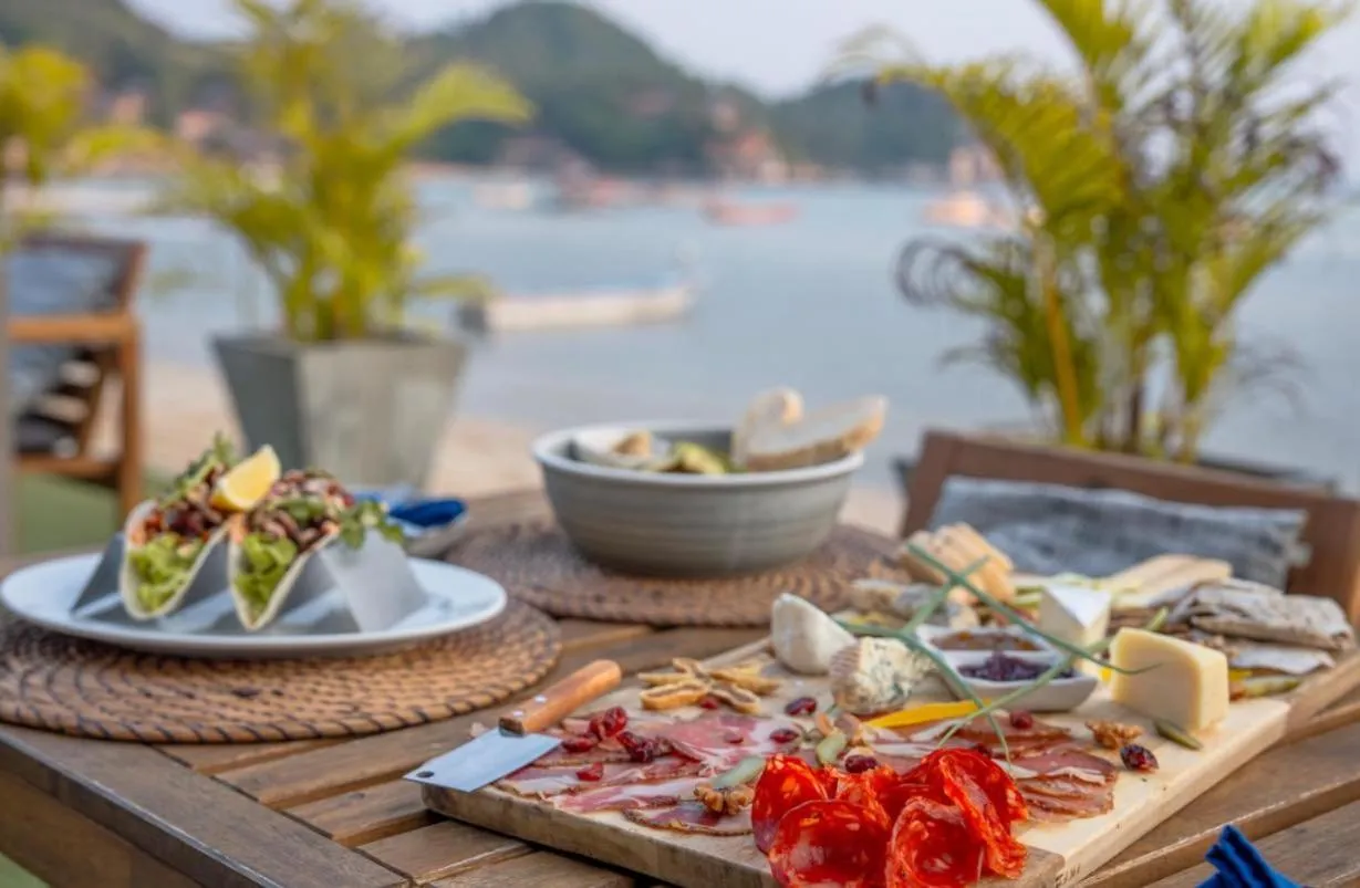 Une table en bois est dressée avec des plats variés et des fruits de mer.