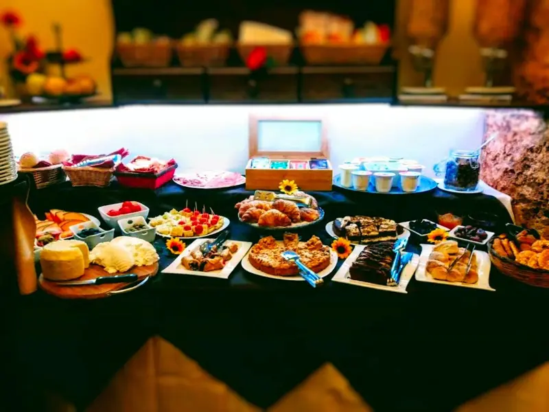 Un buffet propose une variété de pâtisseries, de fruits et de céréales.