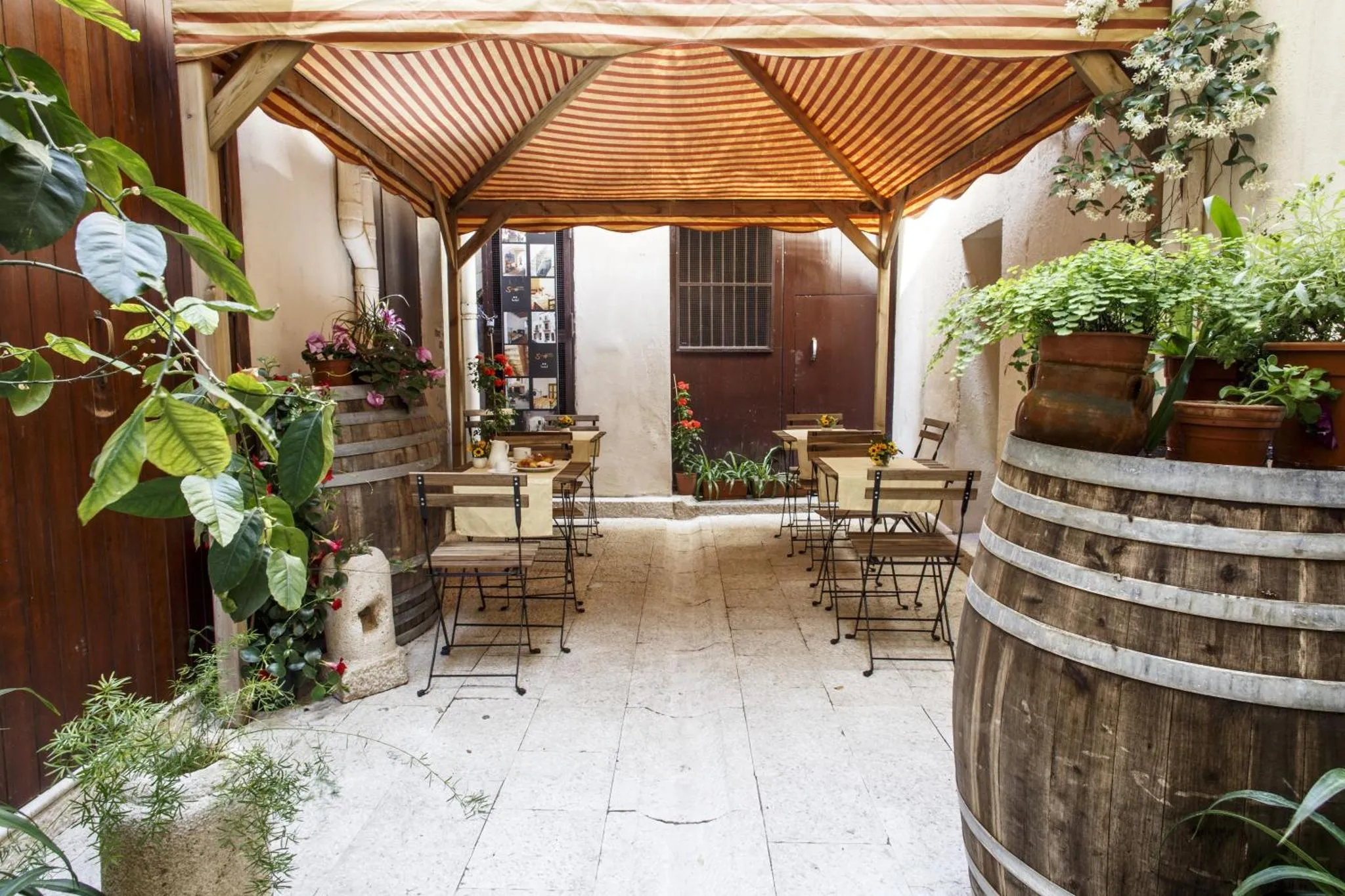 Une cour intérieure ombragée avec des tables et des chaises.