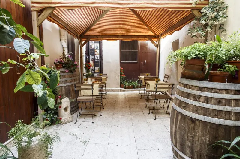 Une cour intérieure ombragée avec des tables et des chaises.